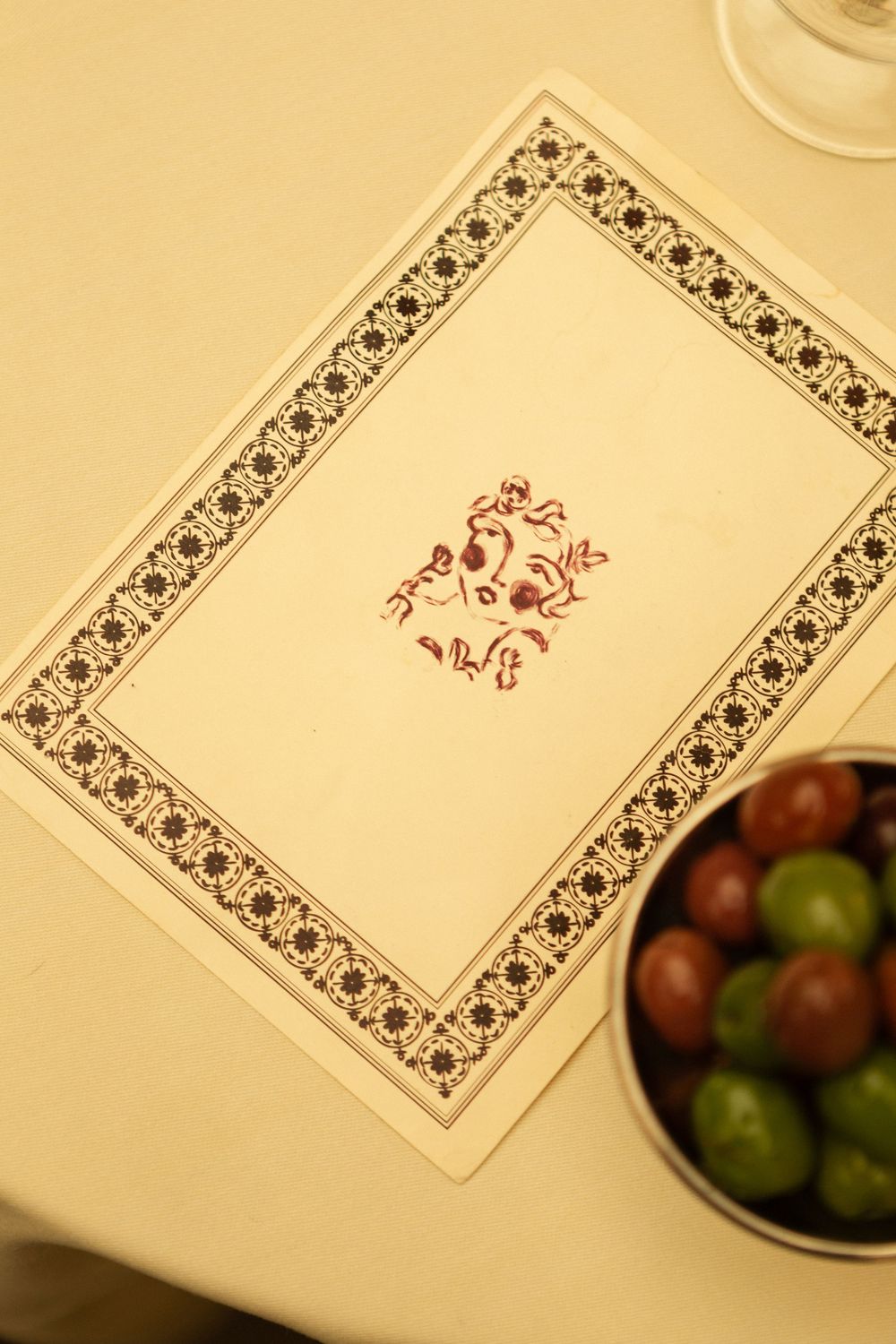 Decorative paper with floral border patterns set on a cream-colored dining table.