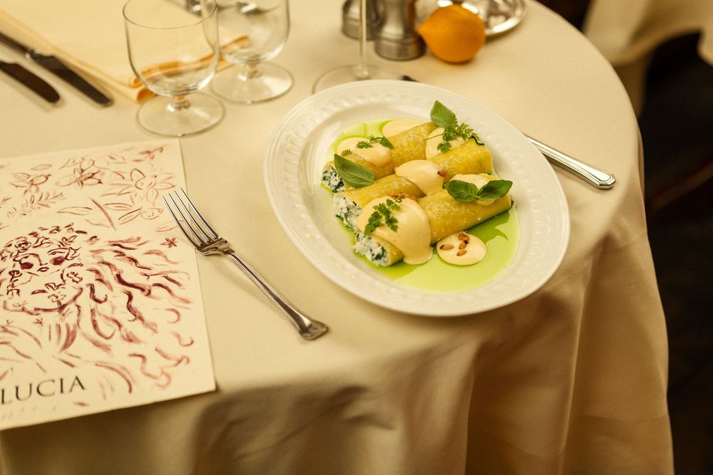 Artistic menu cards displayed alongside plated dishes on an elegant dining table setting.