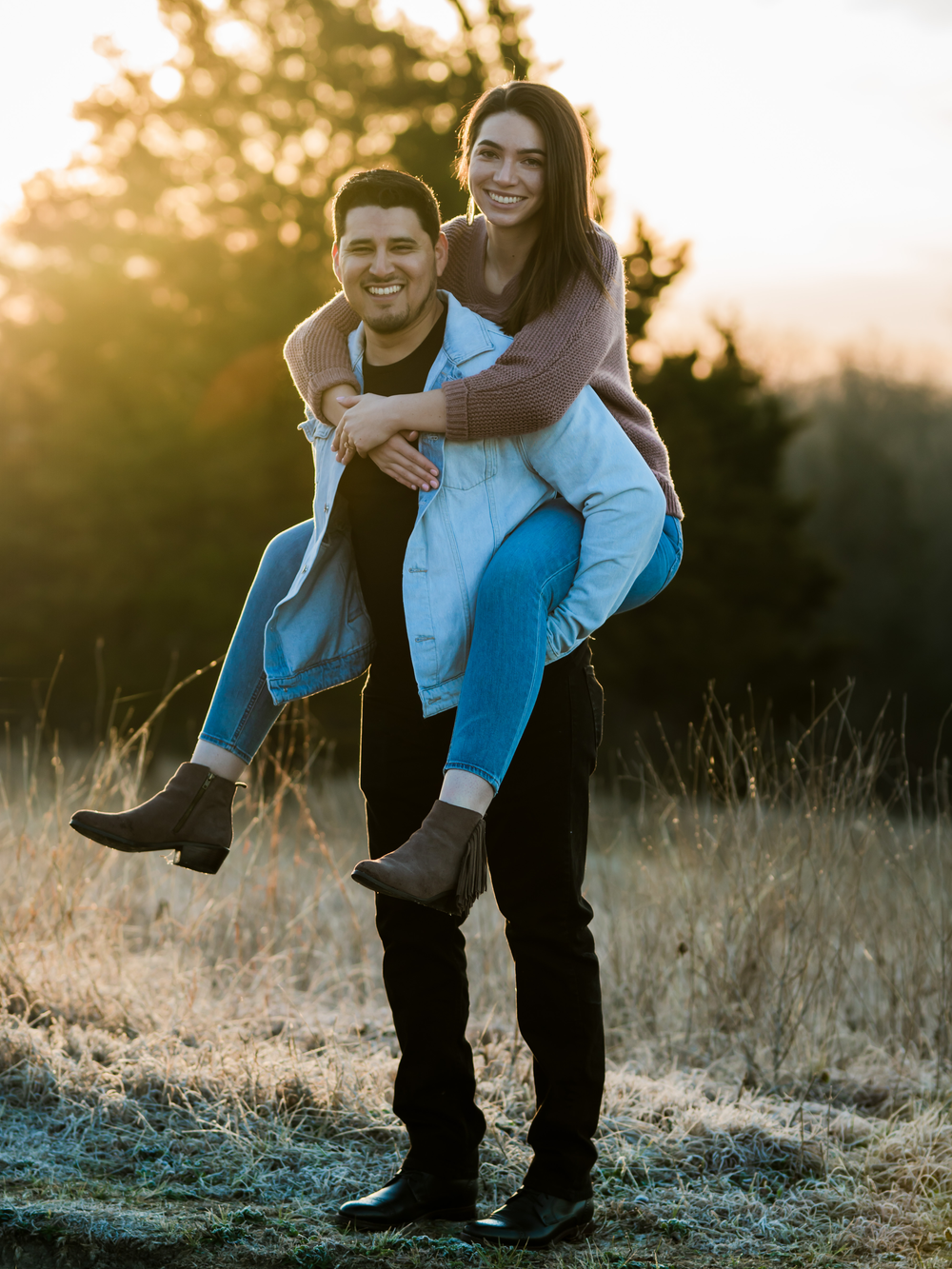 Playful piggyback ride photo session in a field during golden hour.