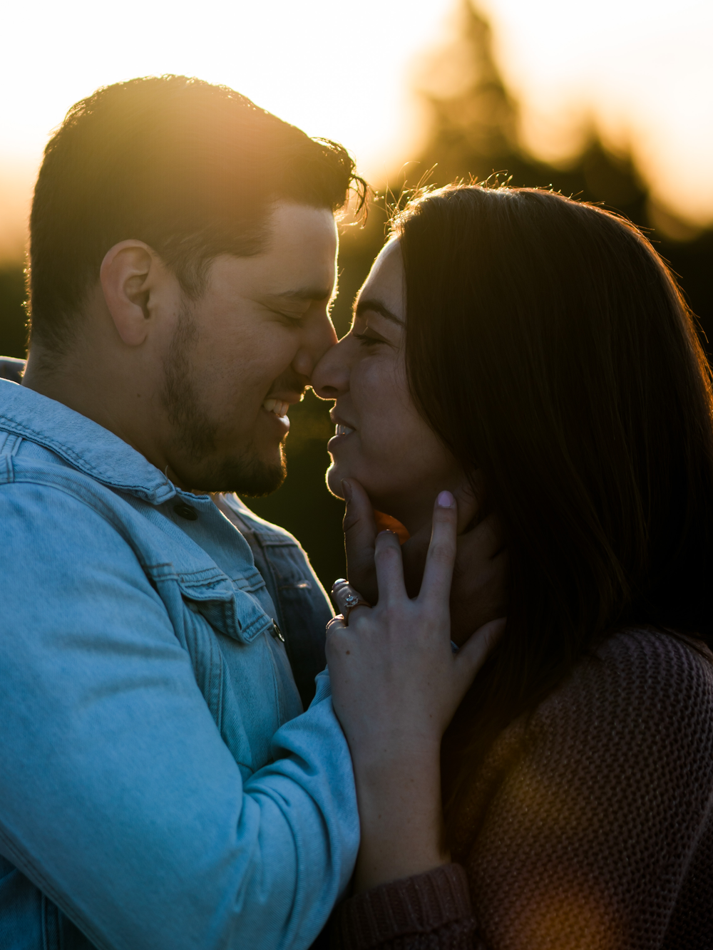 Intimate closeup of couple sharing tender moment in sunset lighting.