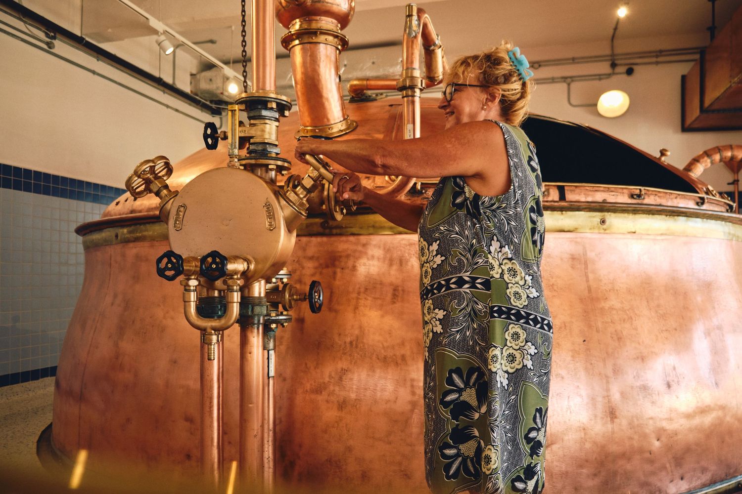 Copper brewing kettles and fermentation tanks in an industrial brewery setting.