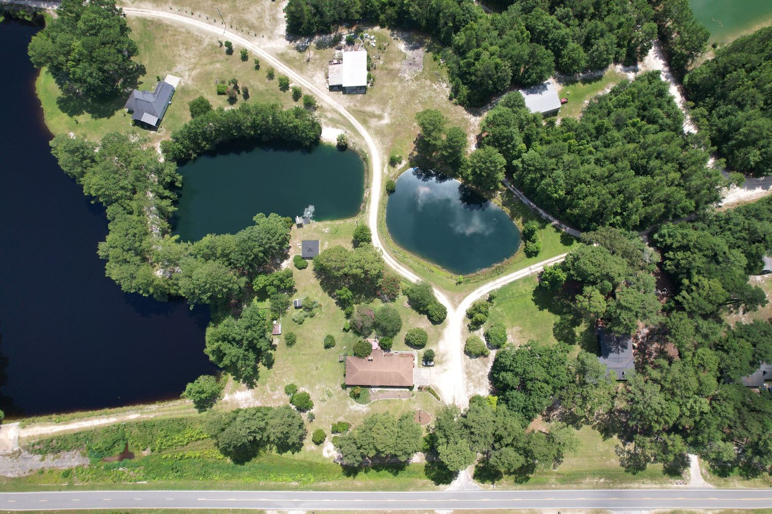 Aerial view of multi home property with numerous blue green lakes surrounding them.