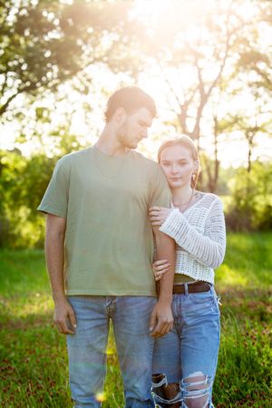 Couple embracing in a field of red wildflowers at sunset.