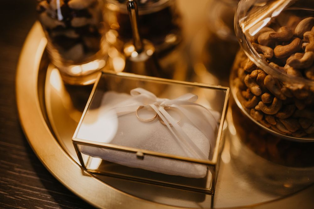 An elegant envelope containing wedding stationery displayed on a golden tray with decorative elements.