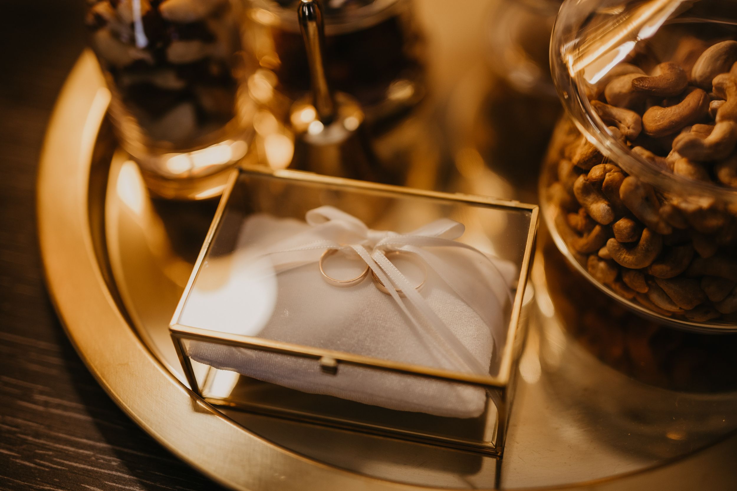 An elegant envelope containing wedding stationery displayed on a golden tray with decorative elements.