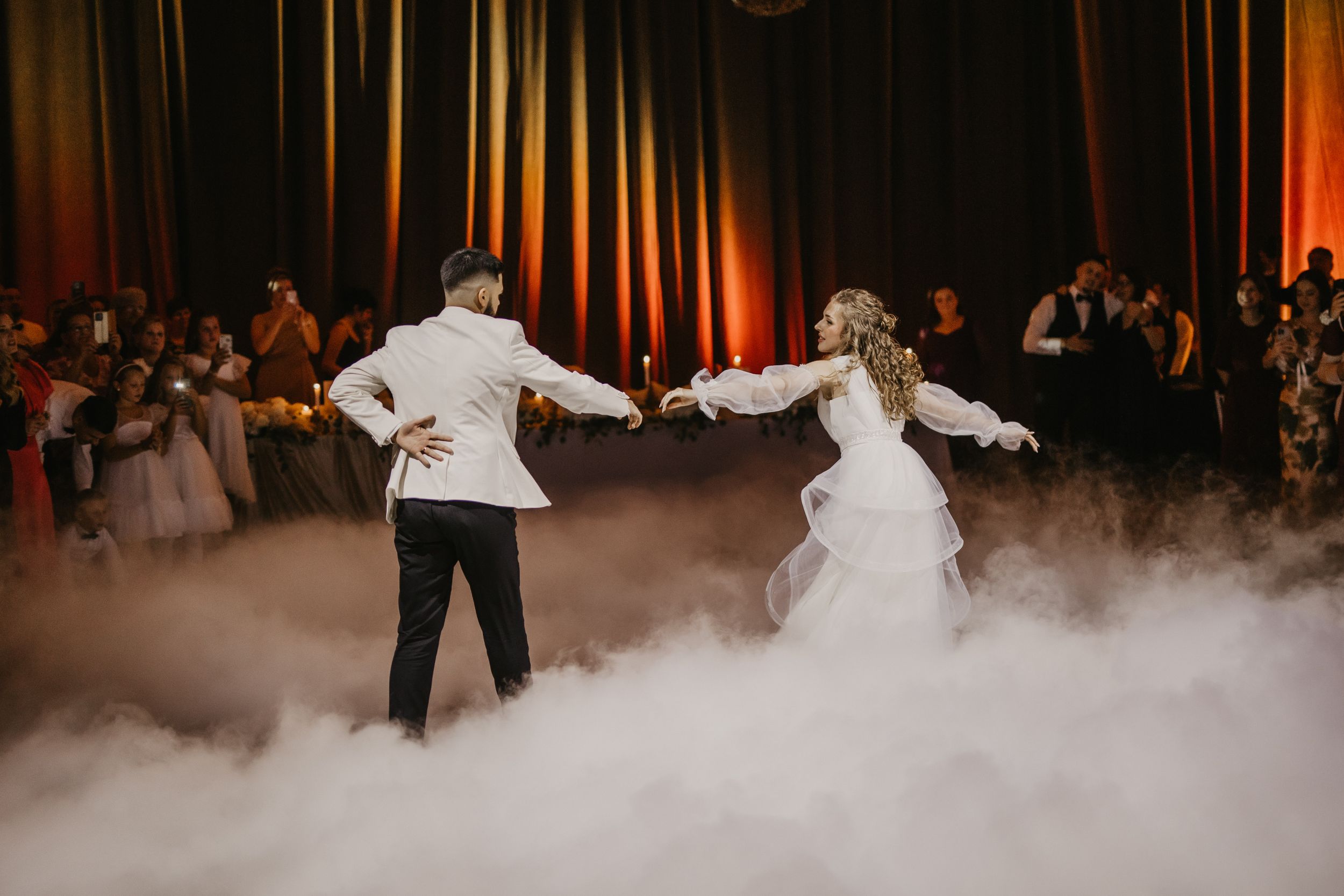 Newlyweds dance on a fog-covered dance floor at their wedding reception.