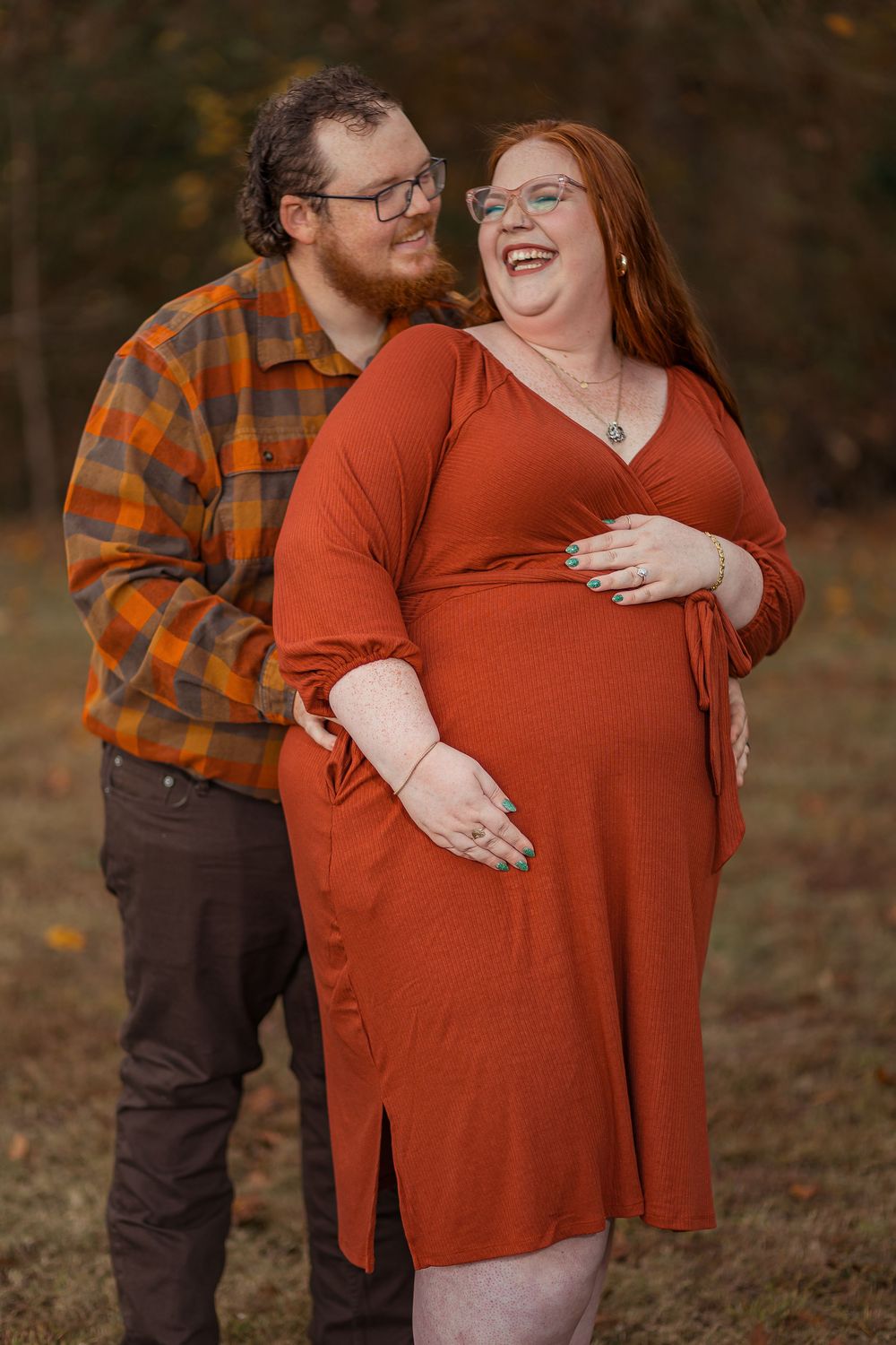 A couple shares tender moments outdoors wearing fall colors with one person in a rust-colored sweater.