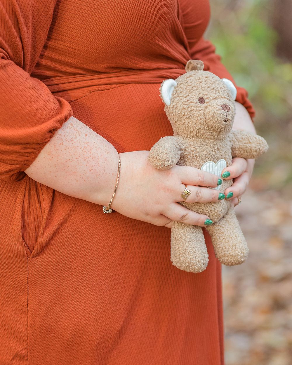 Maternity detail photo of a teddy bear held against a pregnant belly during an outdoor session in Greenville, SC.