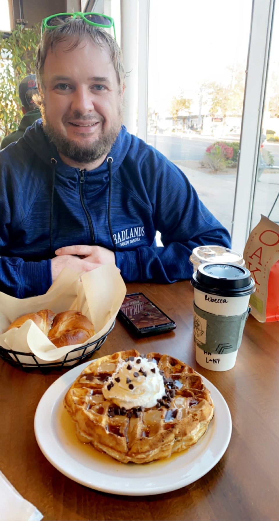 Delicious waffle topped with whipped cream and coffee on a cafe table.