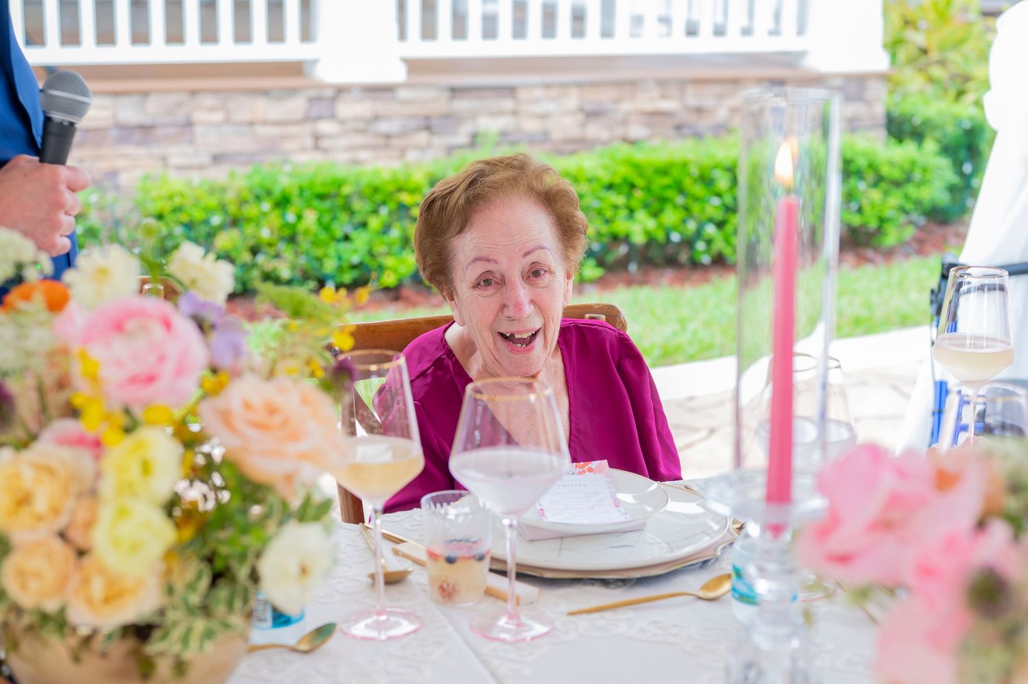 A guest enjoys a lovely outdoor brunch with colorful floral arrangements and table settings at a garden party.