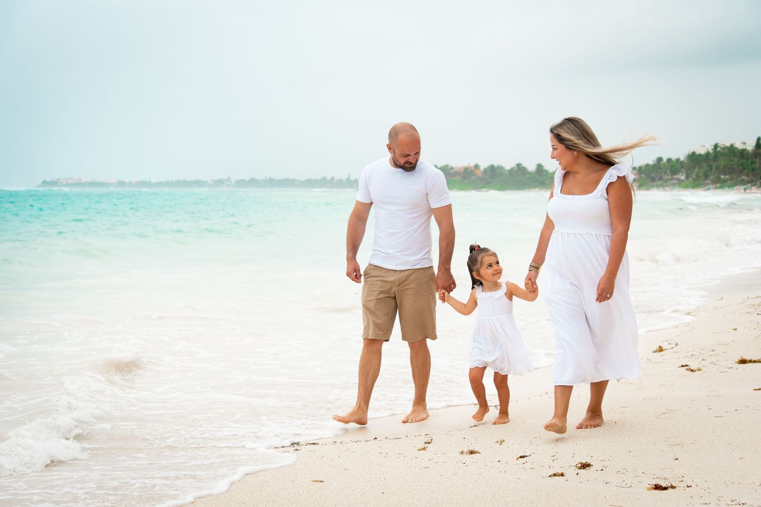 Family walking by the beach during their photoshoot in Akumal, Mexico