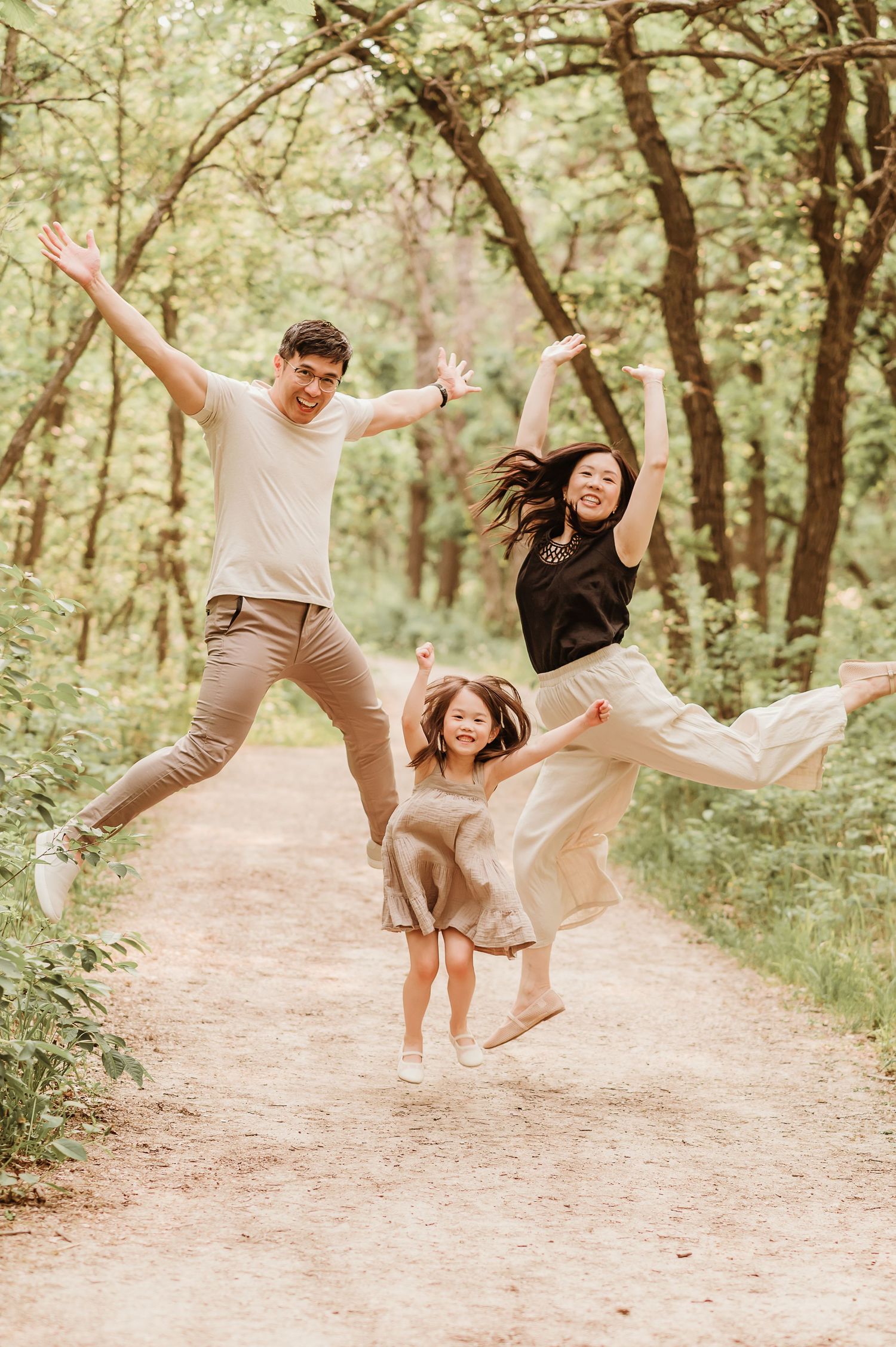 Dynamic sequence of people joyfully leaping and dancing together on a sunlit forest path.
