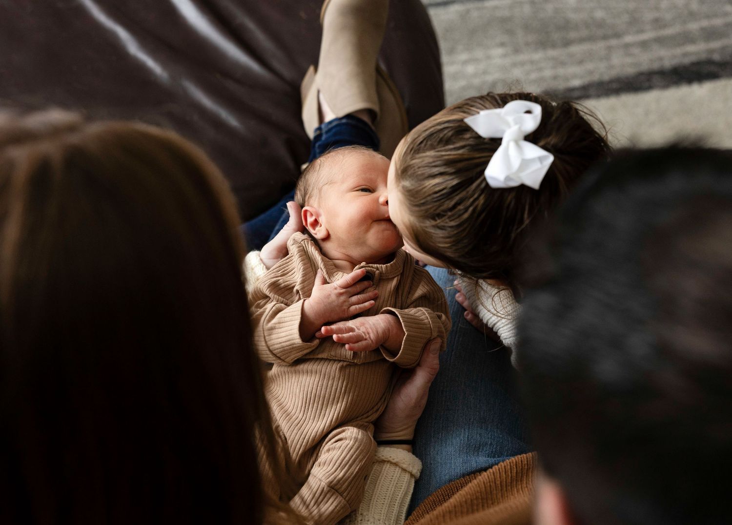 Candid family moments captured on leather couch during holiday session.
