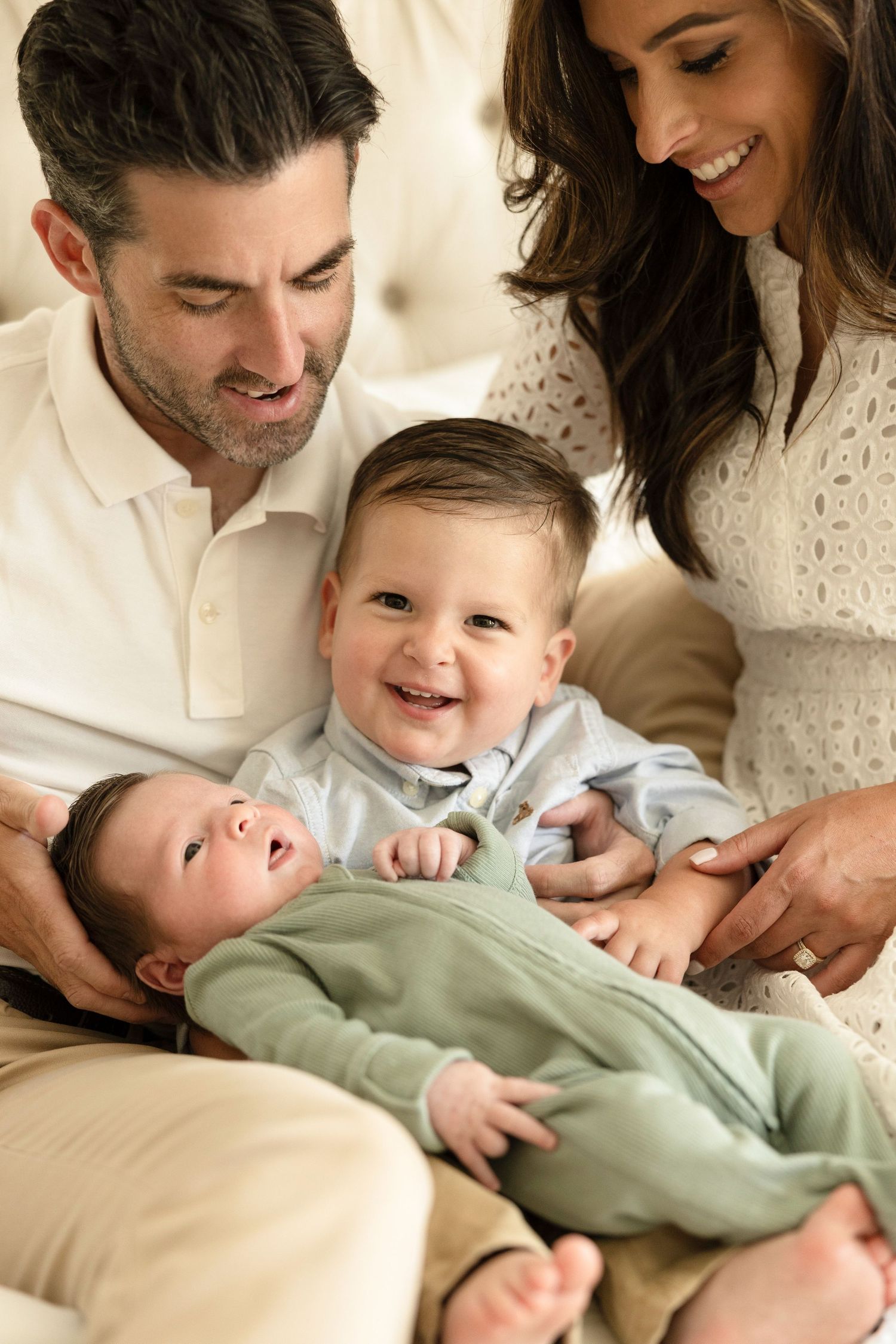 Family sharing playful moments together on a light-colored couch.