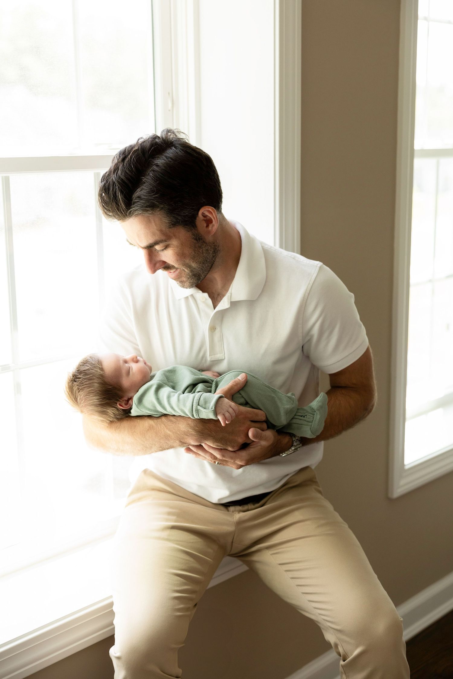 Sweet candid moments between parent and child by a bright window.
