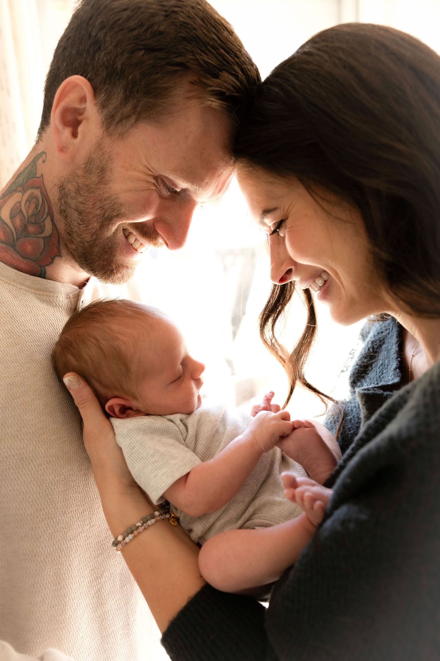 Intimate family moment captured in soft window light.