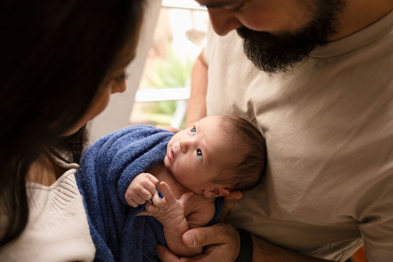 Parents share intimate moments with their infant in a series of connected photos.