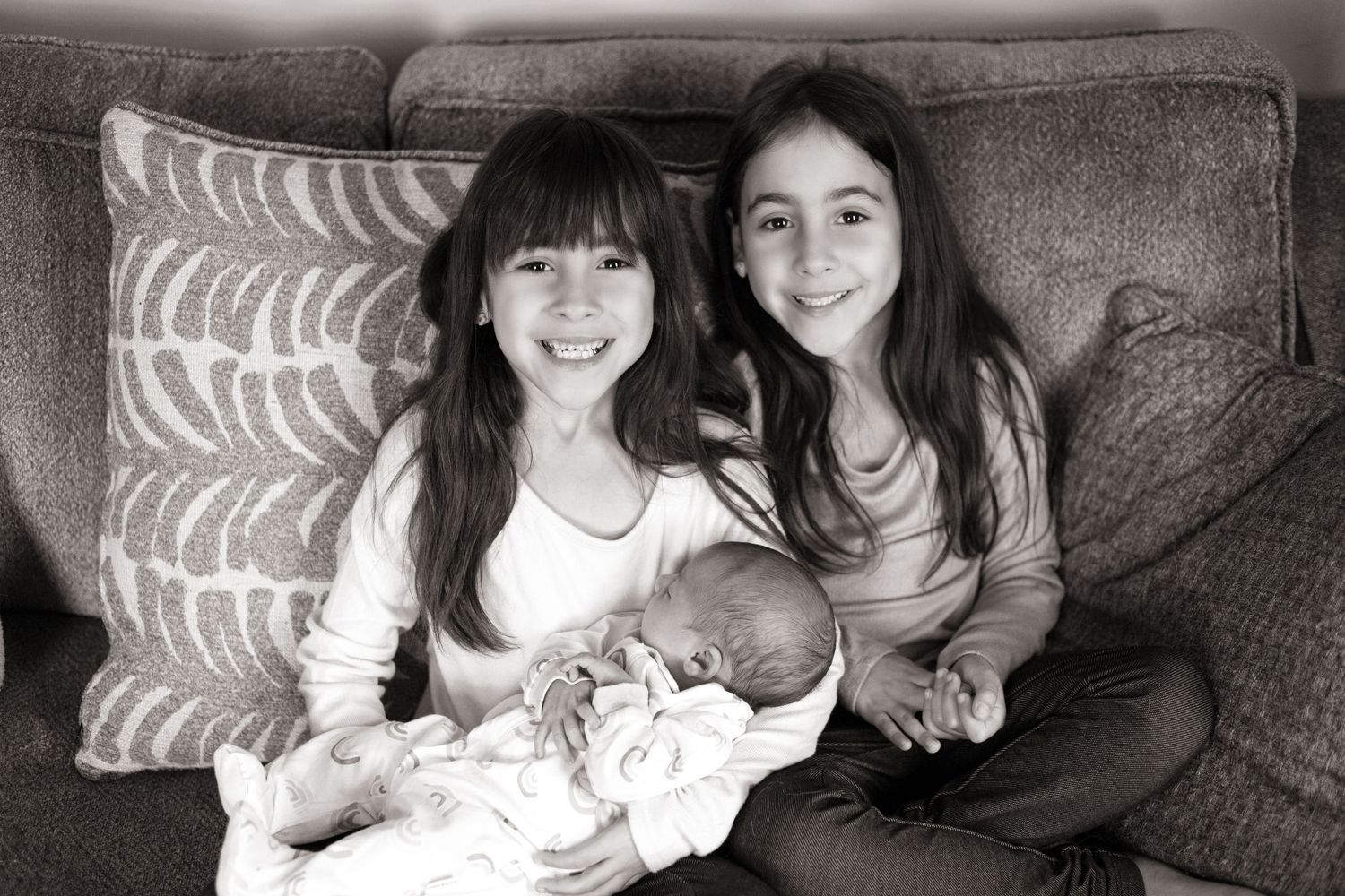 Black and white family portrait session showing intimate moments on a couch.