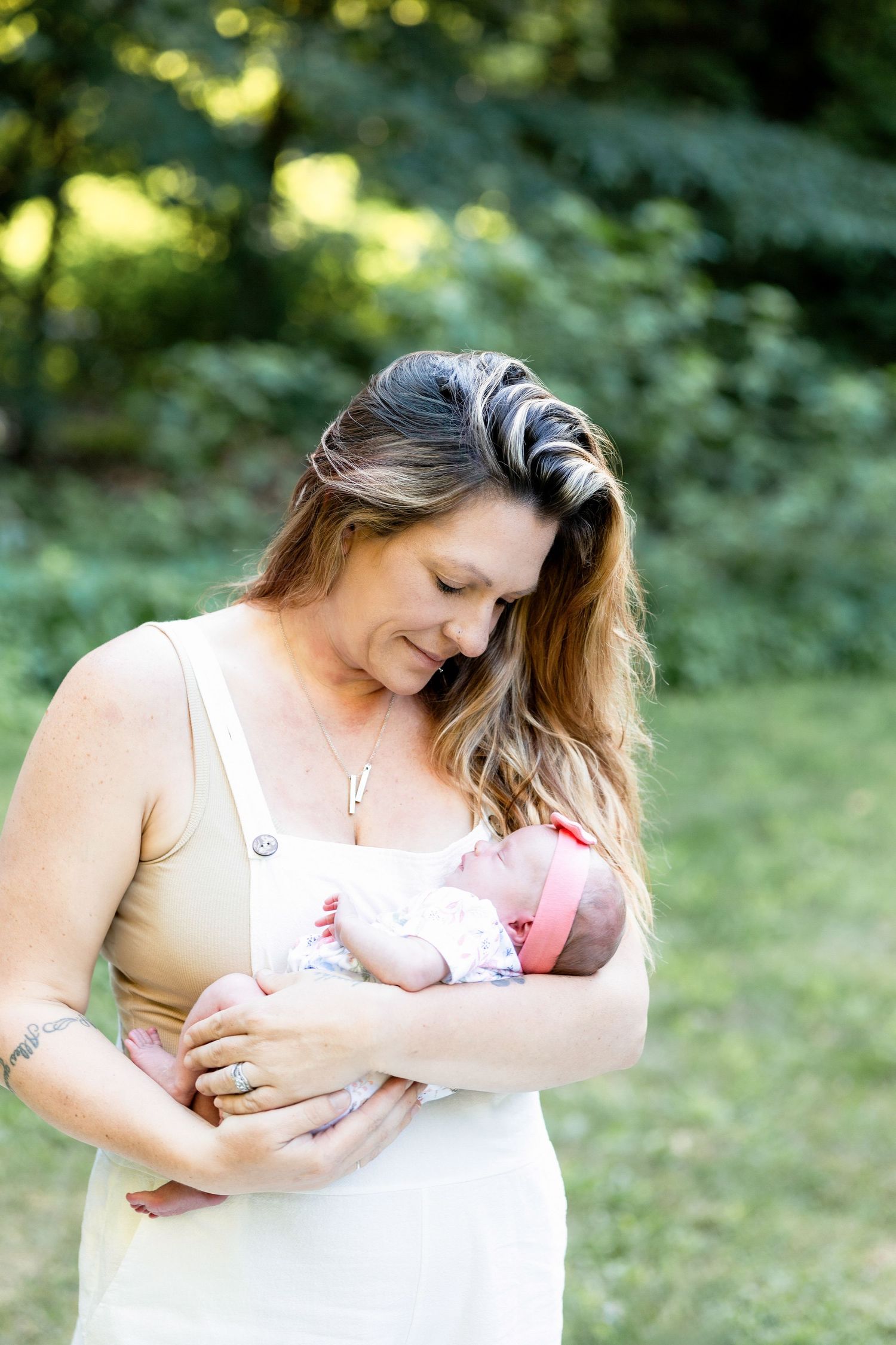 Outdoor breastfeeding photography session in natural sunlit garden setting.