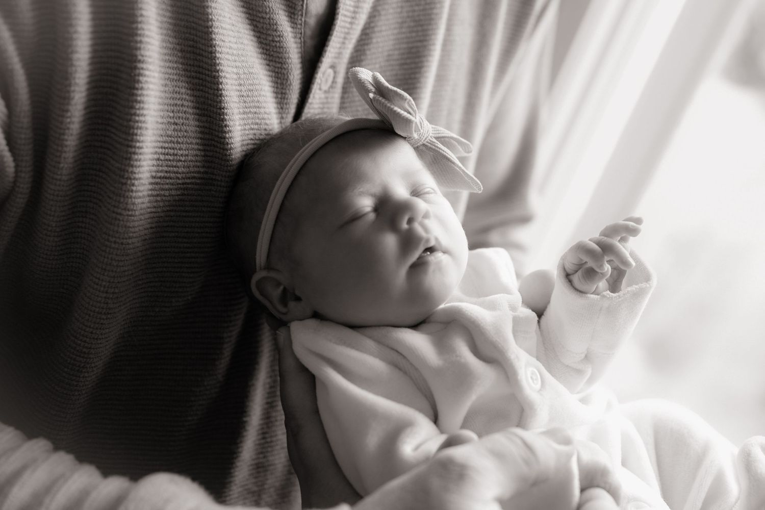 Backlit silhouettes show tender family moments by window.