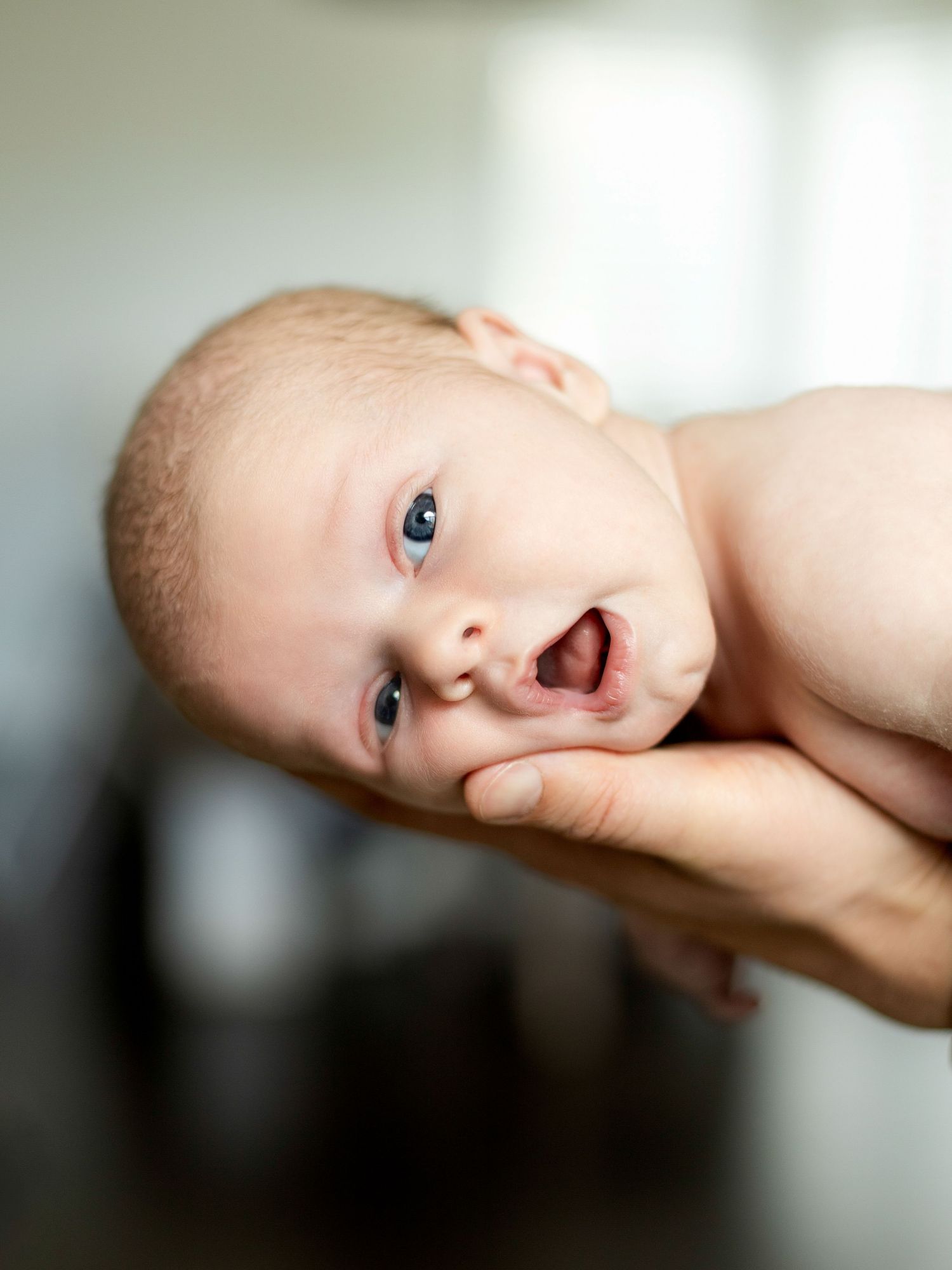 Close-up portrait series of baby resting on arm.