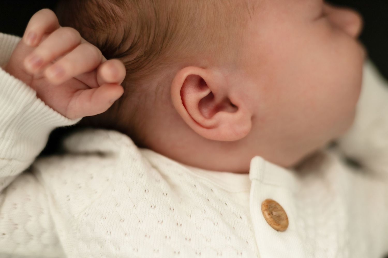 Close-up detail shots of baby's features against neutral background.