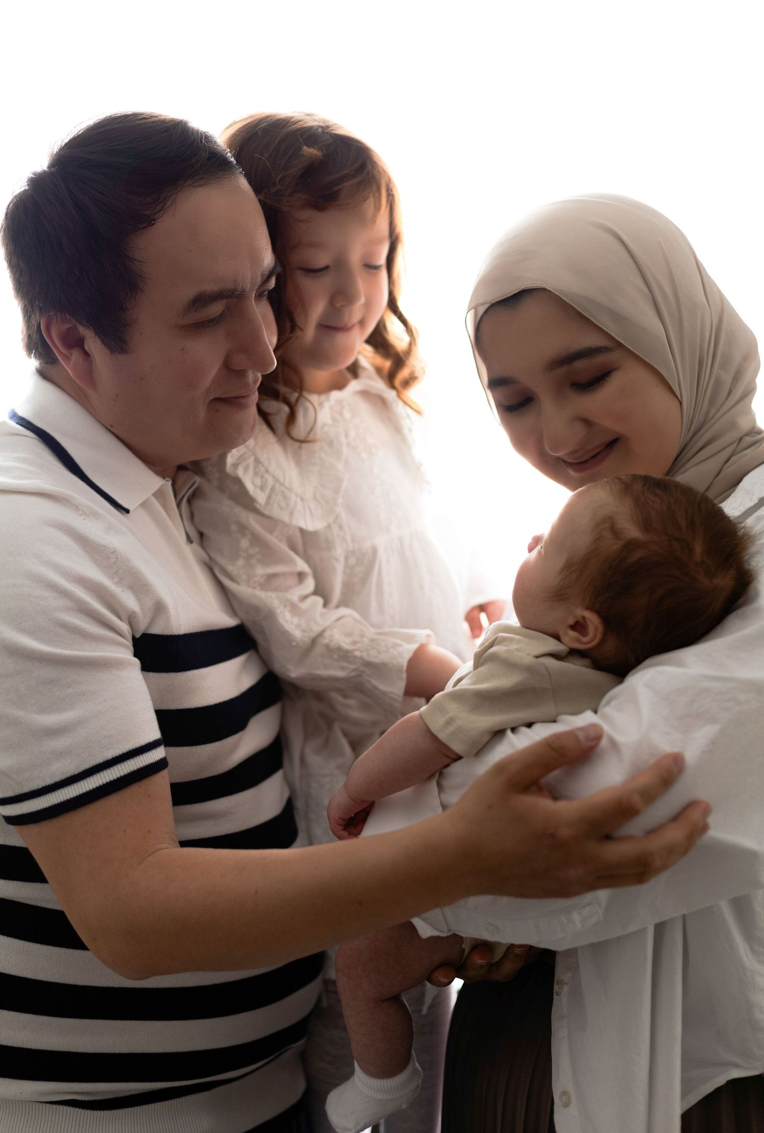 Family sharing intimate moment together during indoor portrait session.