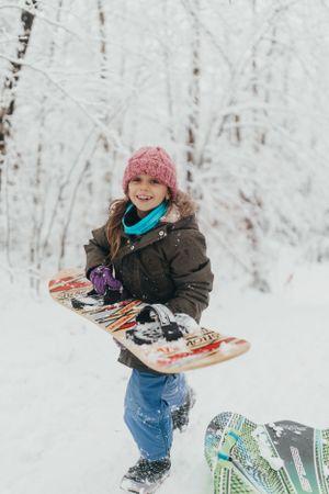 A playful winter scene with someone holding up colorful skis in deep snow.