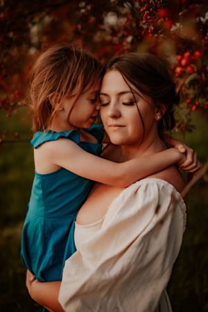 Intimate moment captured in warm autumn light with red berries in the background.