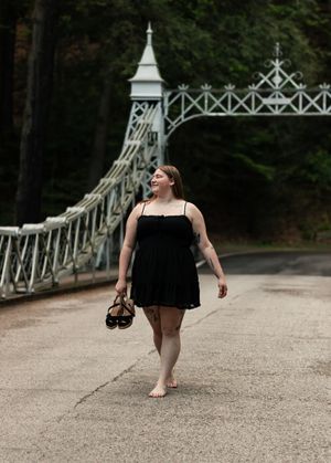Four connected images show a sequence of someone walking on a gravel path near an ornate white footbridge in a park setting.