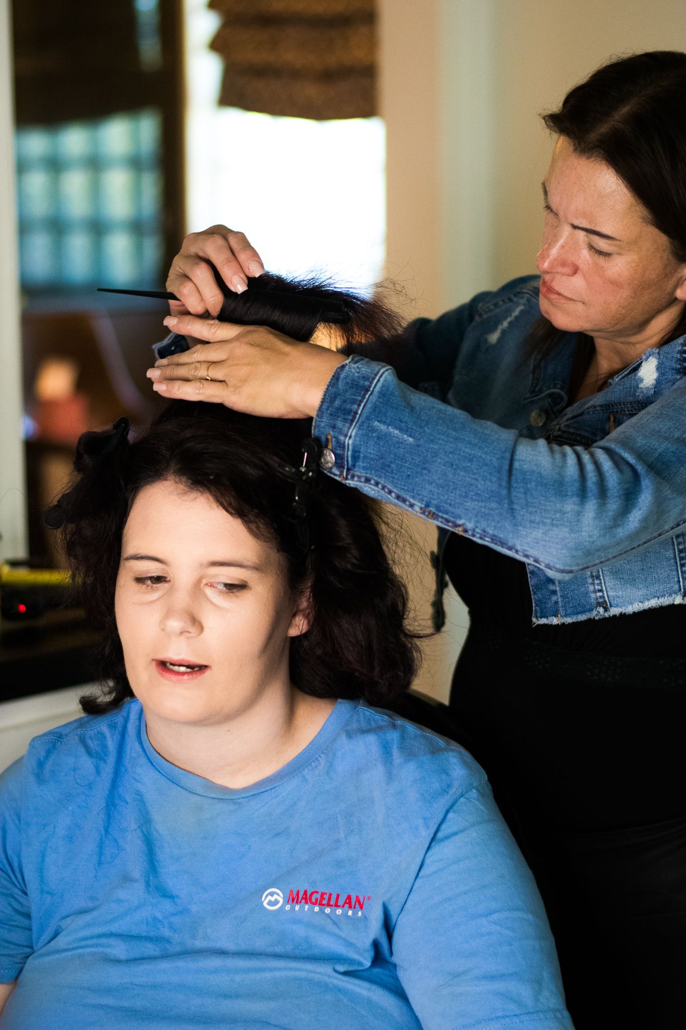 Hair styling session in progress with stylist working on client's dark curls.