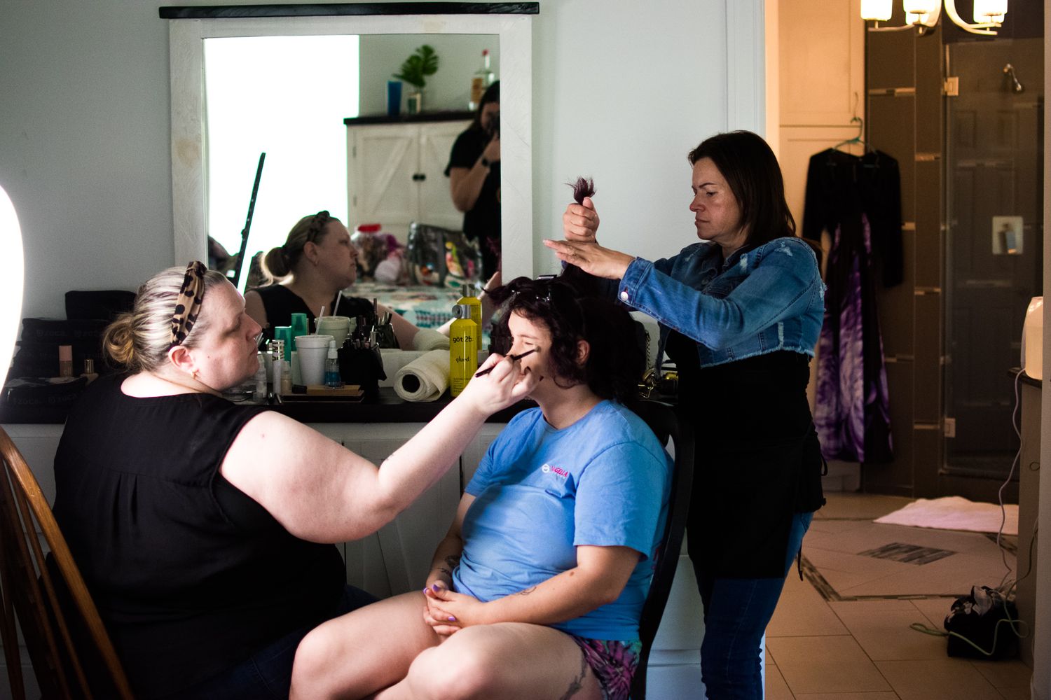 Multiple people gathered during an informal hair styling session at home.