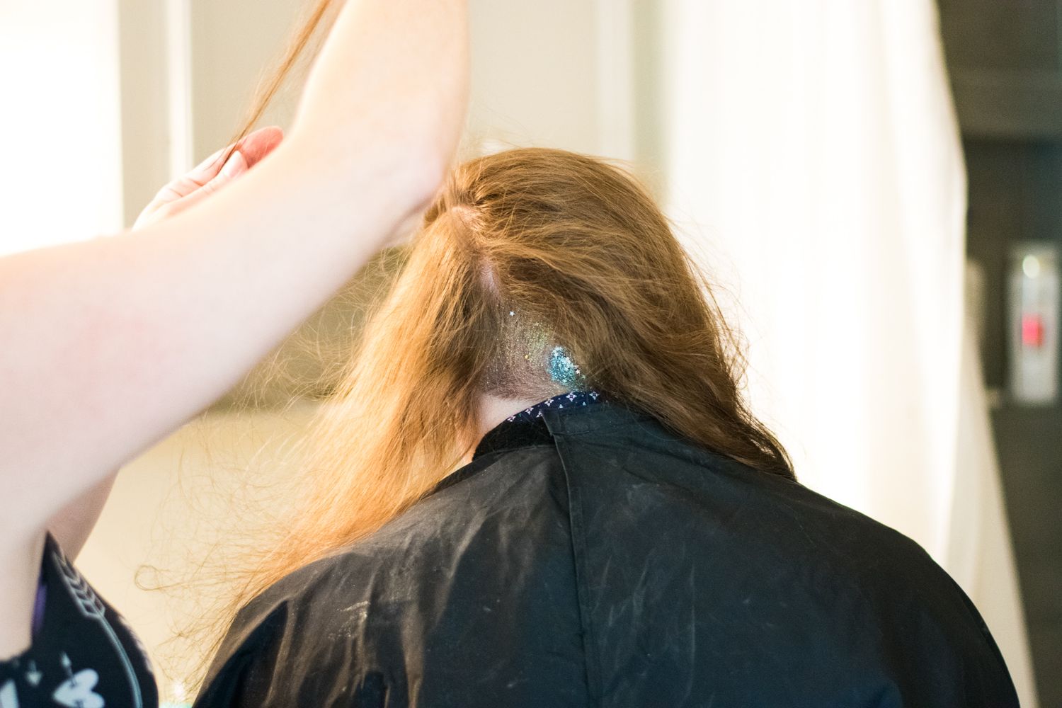 Close-up of hair being styled with glitter or shimmer products.