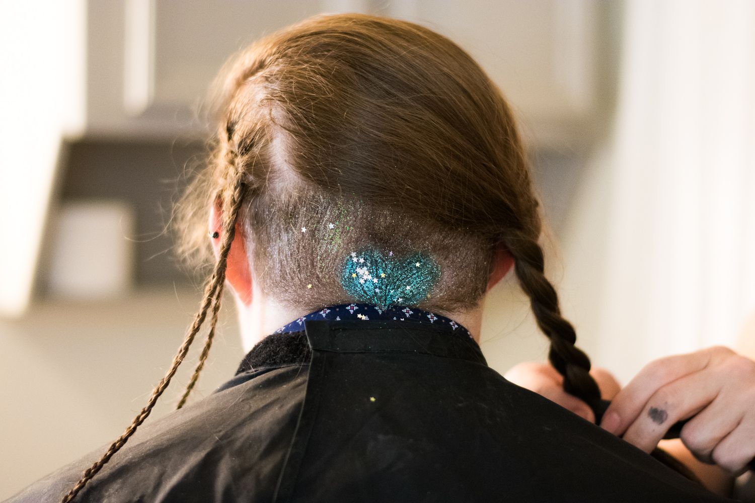 Close-up of braided hair with blue glitter or sparkles.