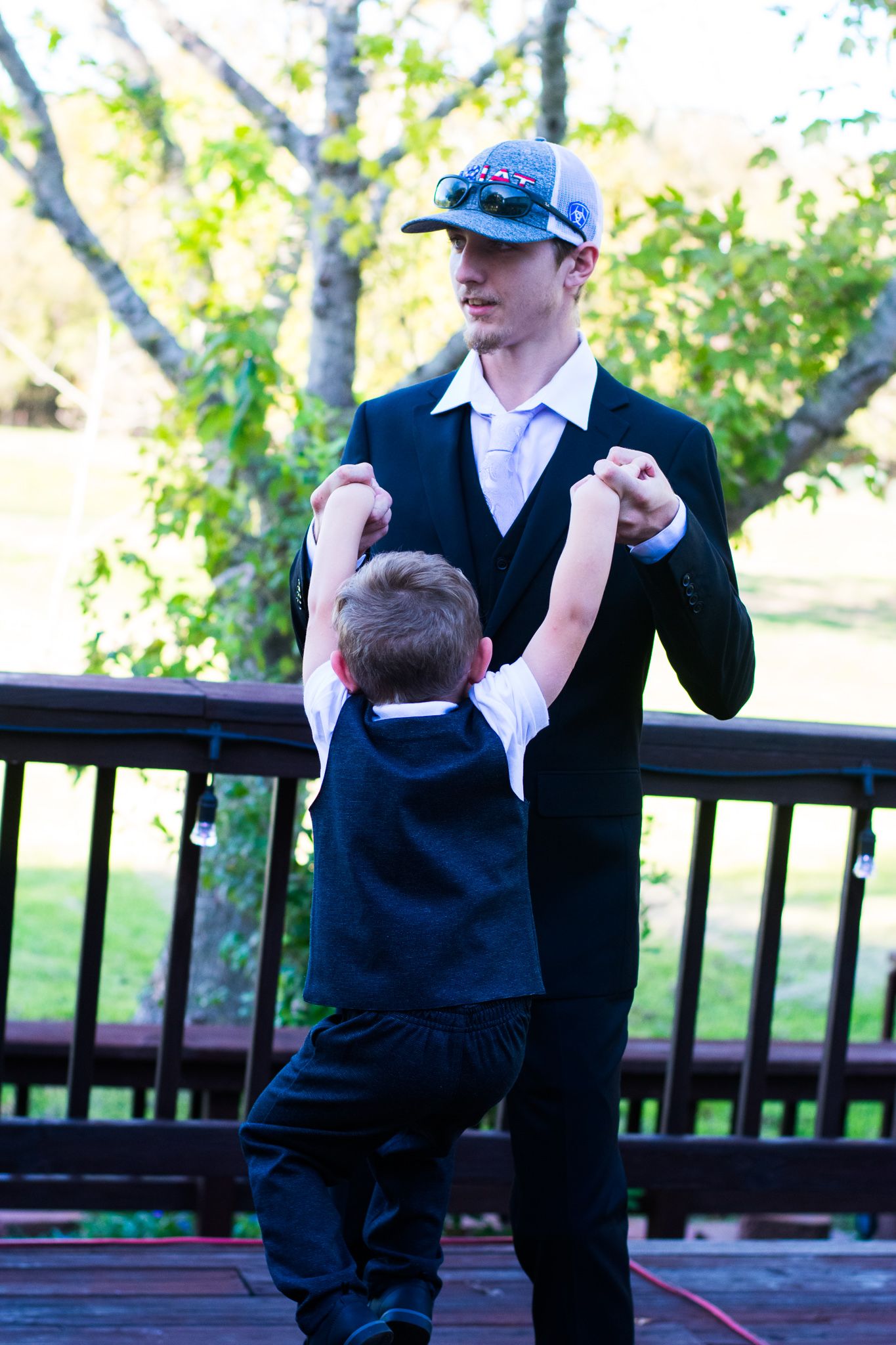 A sweet moment captured between two people sharing a dance or interaction on an outdoor deck.