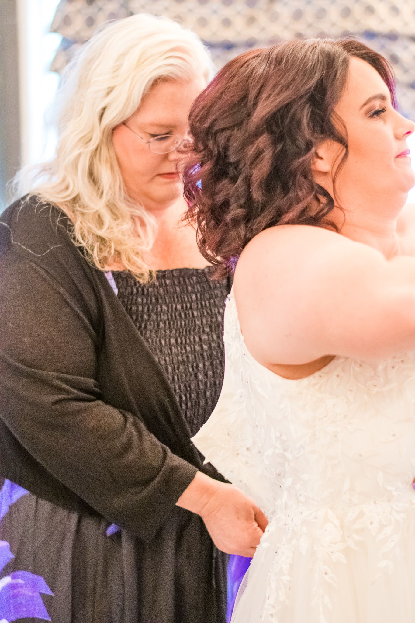 Final dress adjustments being made before the wedding ceremony.