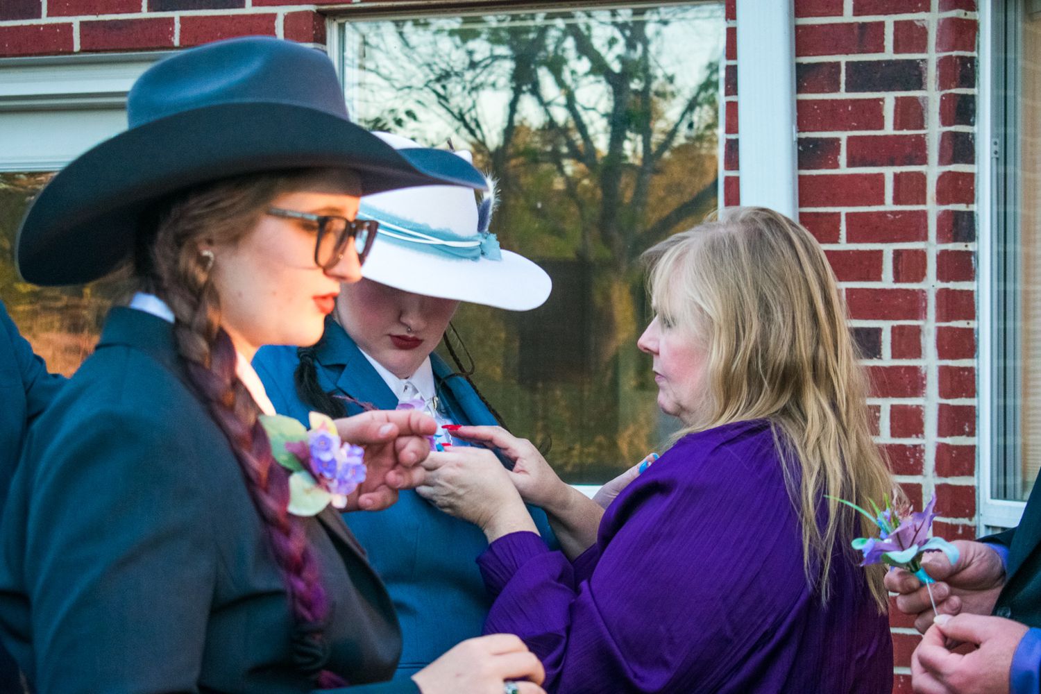 People exchanging corsages at an outdoor western-themed gathering.