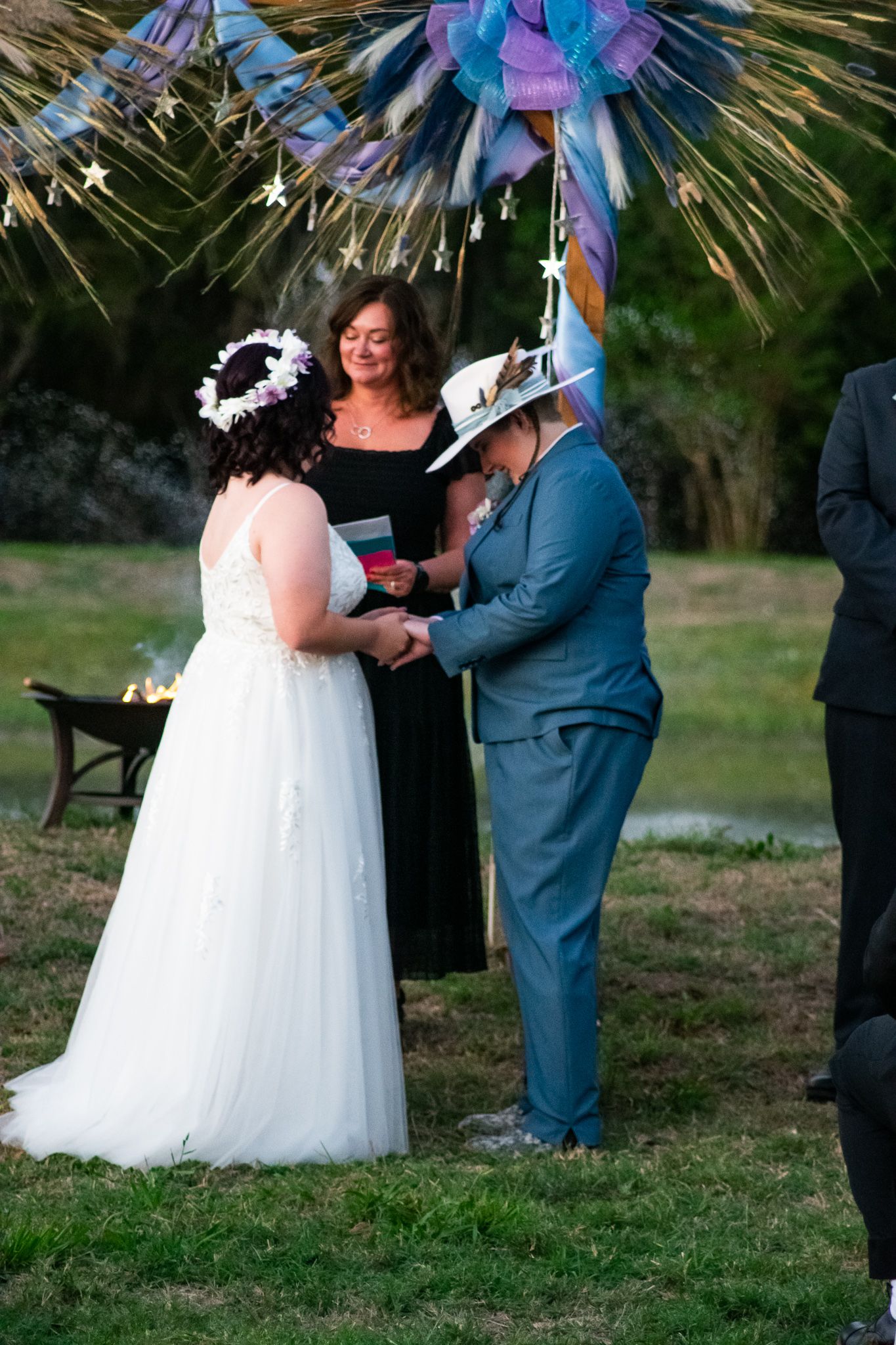 A wedding ceremony under a sparkly decoration arch with attendees exchanging vows.