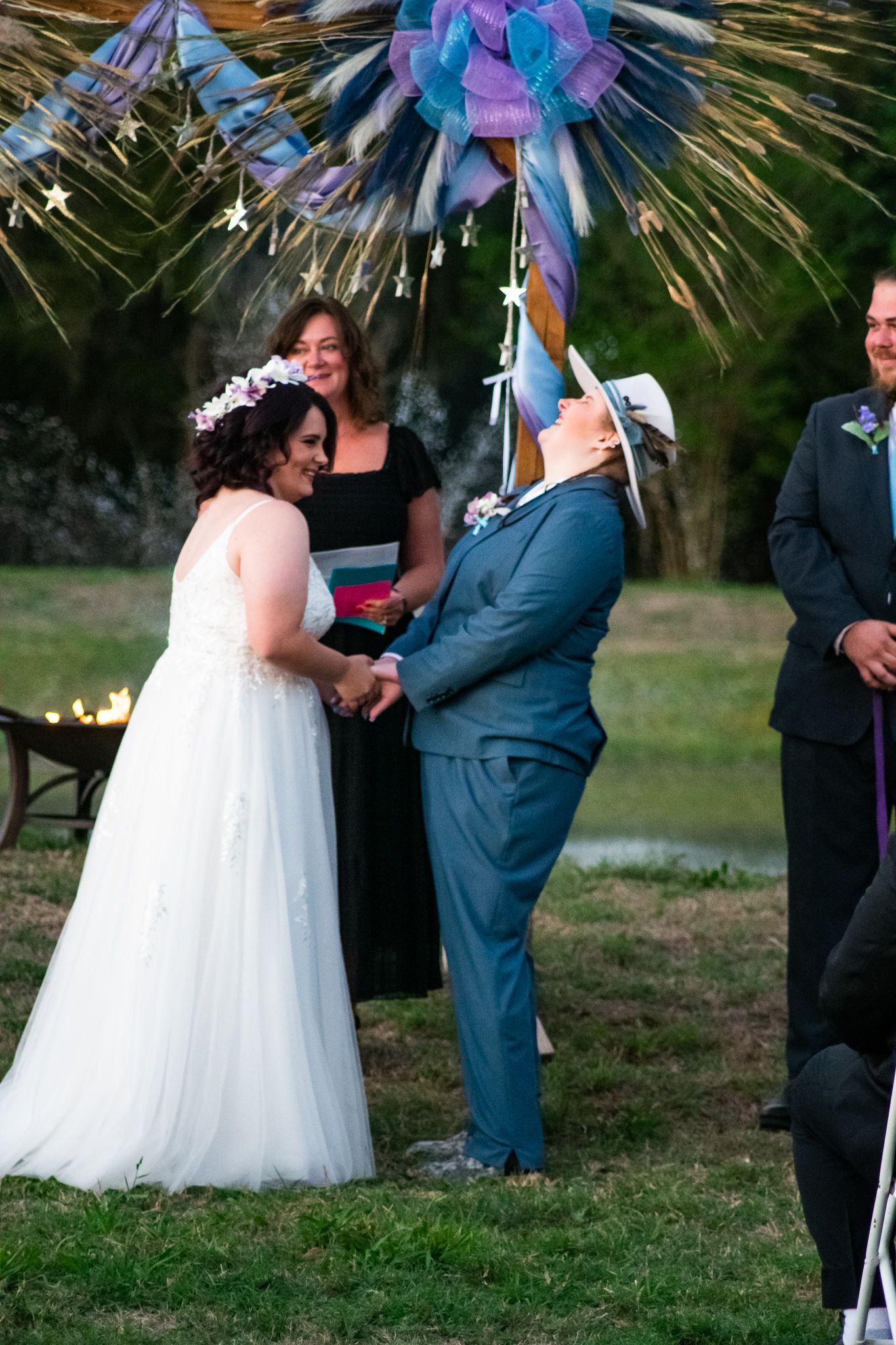 A wedding ceremony moment under colorful decorative stars with attendees in formal attire.
