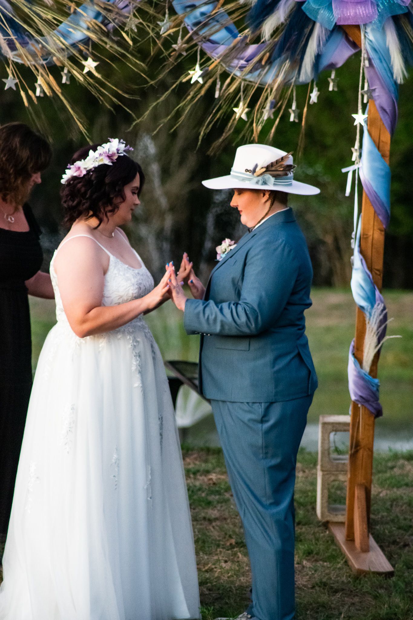 Wedding ceremony under a decorated arch with a couple exchanging vows.