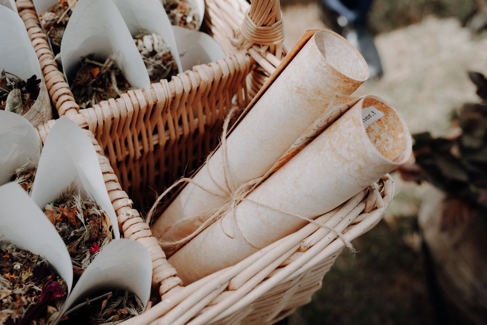 Artistically arranged white paper cones in woven baskets for wedding ceremony.