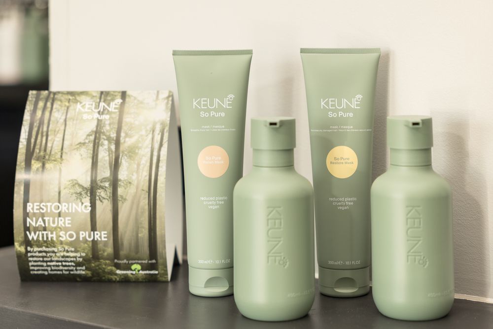 Collection of green Keune hair care products displayed on counter.