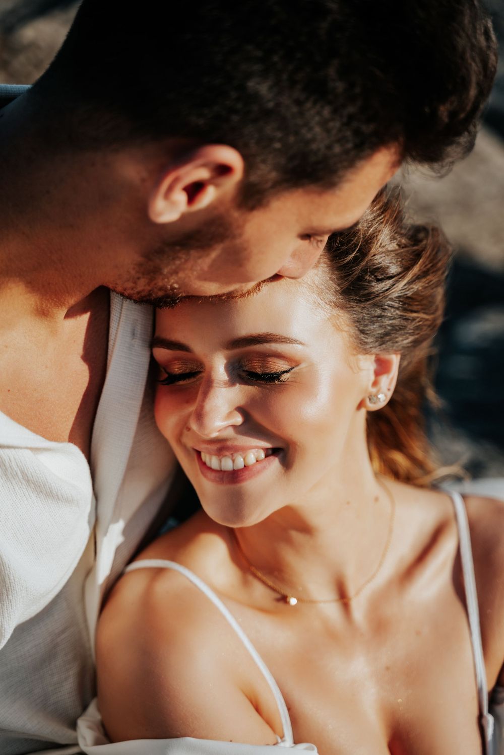 An intimate close-up portrait of a couple sharing a tender moment in natural lighting.