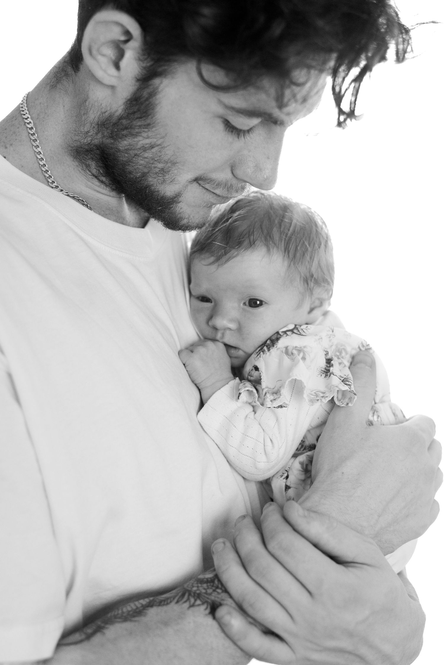 A black and white close-up portrait showing a tender parenting moment.