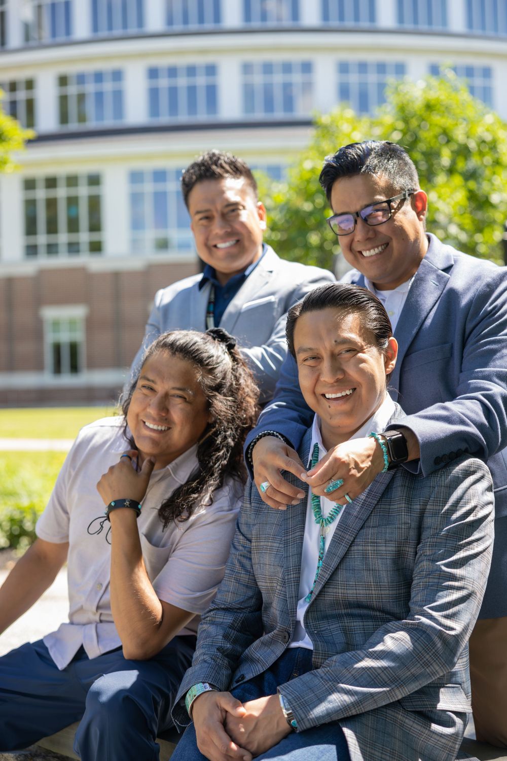 Group enjoying a lighthearted moment together outdoors near a building.