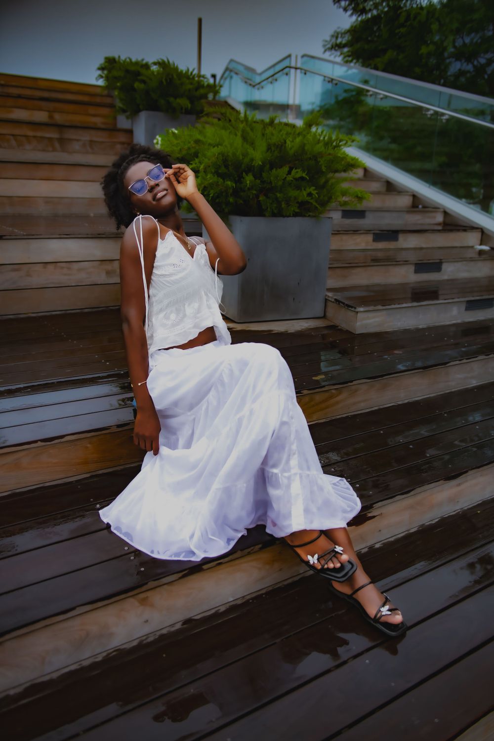 Joyful moment captured on wooden steps wearing a white summer ensemble.