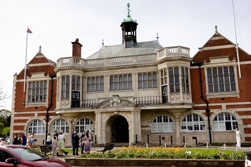 Historic red brick building with white trim and ornate Victorian architecture featuring a central tower.