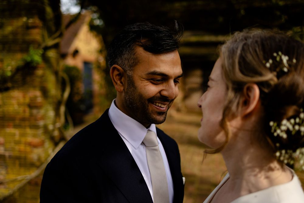 A romantic moment captured between newlyweds in an outdoor garden setting.
