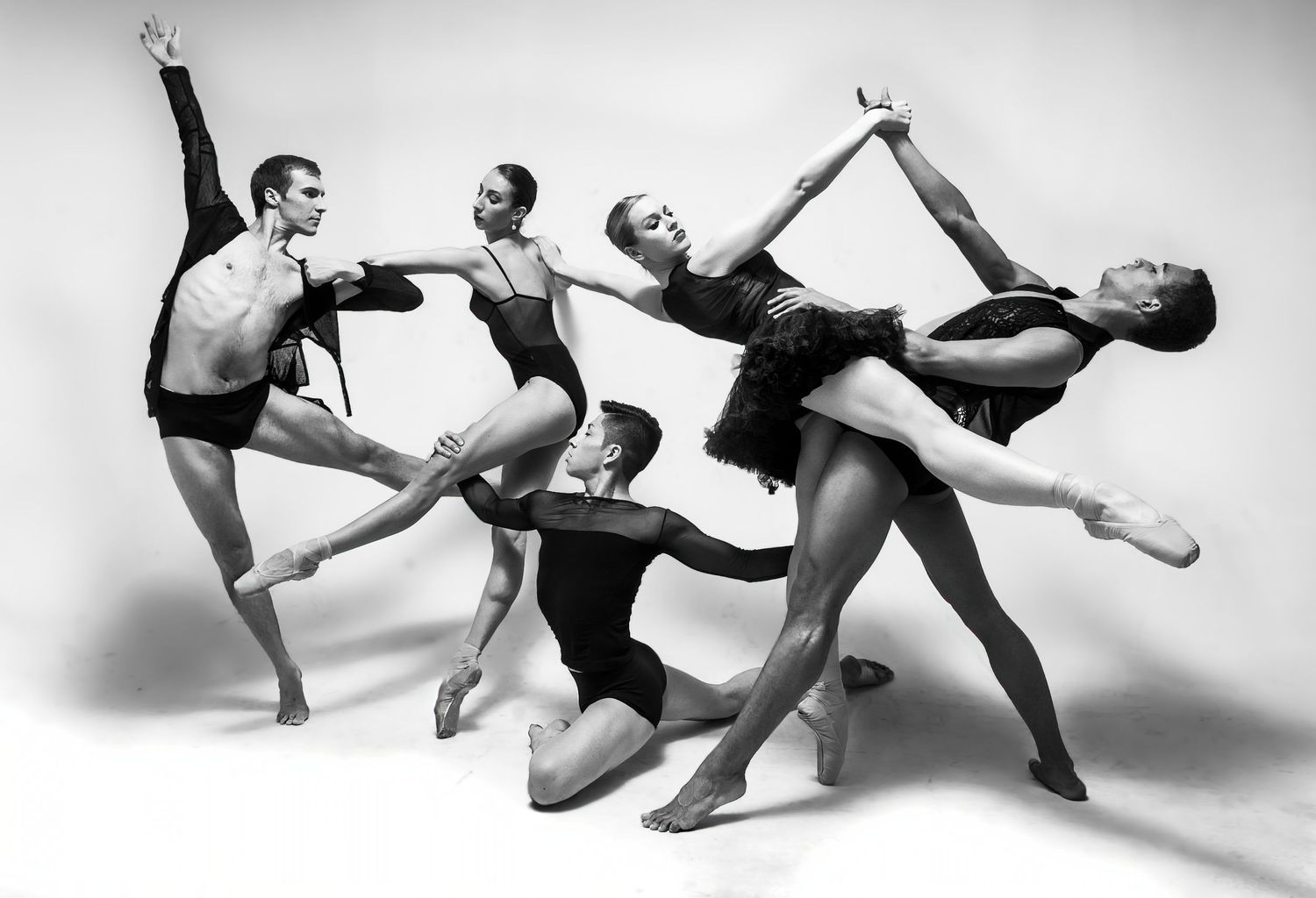 Black and white photo of modern dancers creating dynamic geometric shapes through movement.