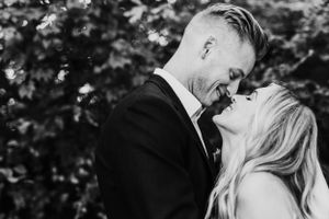 Black and white intimate moment captured between couple at outdoor wedding.